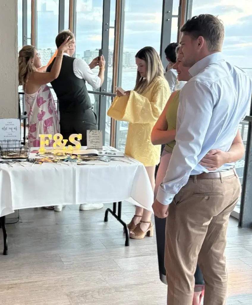 Gasten op een trouwfeest in een zaal met zicht op zee