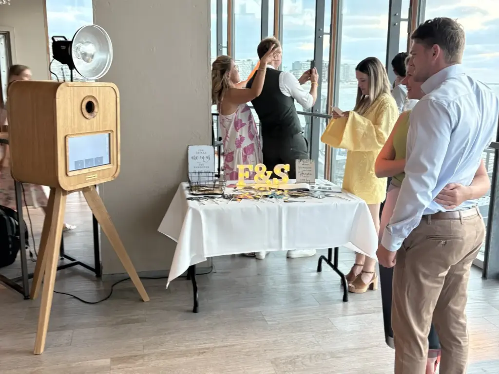 De houten MemoryCabin op een trouwfeest, naast de tafel met props